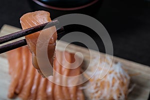 Closeup chopsticks raw salmon sashimi