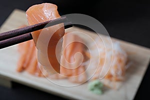 Closeup chopsticks raw salmon sashimi