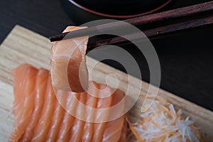 Closeup chopsticks raw salmon sashimi