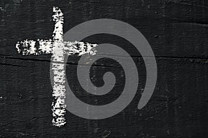 Christian cross on a dark gray wooden surface photo