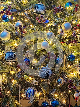 closeup Christmas tree decorated with white and blue glass spheres in living room at home parties