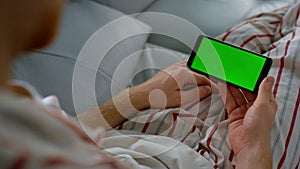 Closeup chroma key smartphone in hands. Unknown man resting with gadget morning.