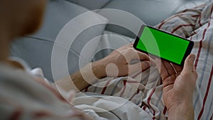 Closeup chroma key smartphone in hands. Unknown man resting with gadget morning.
