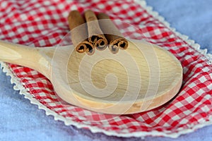 Closeup of cinnamon sticks on a wooden spoon