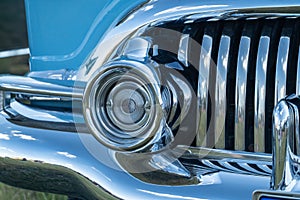 Closeup of a classic blue car's headlight