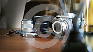 Closeup of classic camera on a wooden desk with wrist watch and len equipment selected focus. Background with a beautiful