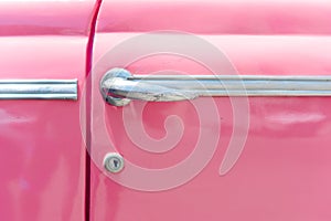 Closeup of classic pink vintage car in Old Havana, Cuba. The most popular transportation for tourists are used as taxis.