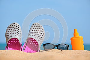 Dettagliato da zoccoli calzature crema un nero protettivo occhiali da sole sul sabbioso Spiaggia sul tropicale costa sul Caldo soleggiato 