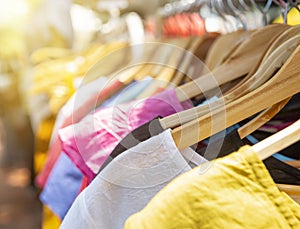 Closeup cloths on wooden hanger on the rail at the market, fashion and shopping concept