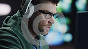 Closeup coder hands typing keyboard in night data center. Man enjoying music