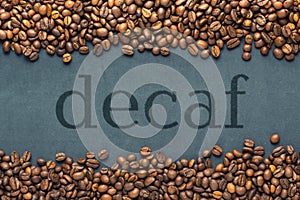 Closeup of coffee beans on grey background with the inscription decaf