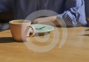 Closeup of coffee cup and saucer at breakfast in modern cafe