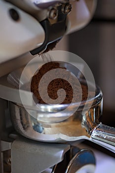 Closeup of coffee grinding into holder, in modern grinder