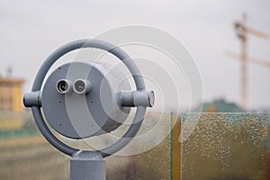 Closeup coin operated binoculars overlooking after rain