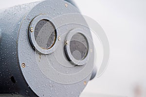 closeup coin operated binoculars overlooking after rain