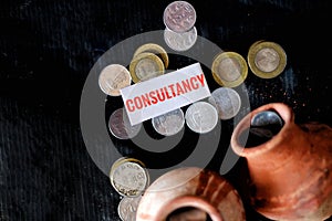 Closeup of coins and clay jugs with a small piece of paper with a message.