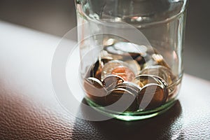 Closeup coins in glass jar using as financial and money savings