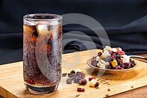 Closeup of cold cola water with ice cubes in transparent glass