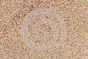 Closeup of color sand on the beach with small peaces of broken s