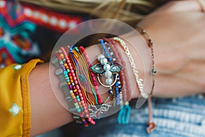 closeup on colorful boho bracelets and rings on wrists photo
