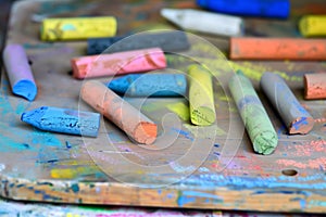 closeup of colorful chalks on wooden artists palette