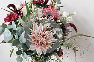 Closeup of colorful flowers. Moody autumn wedding or birthday bouquet. Pink and burgundy dahlia, cosmos and aster