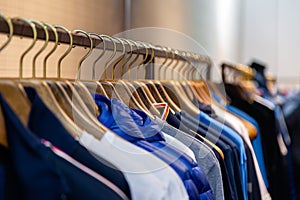 Closeup colorful male, female clothes in boutique hanging on hangers, clothing rack on metal stand. Concept opening