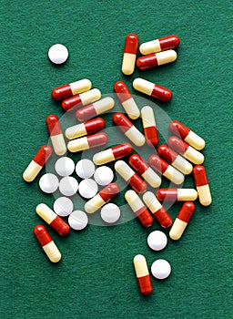 Closeup of colorful medical capsules and pils on green