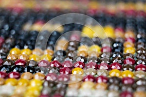 Closeup on colorful mix of round drill beads for diamond painting. Multicolored rainbow of shiny beads for background art. Macro