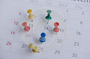 Closeup colorful pins push marking on a calendar. busy schedule