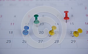 Closeup colorful pins push marking on a calendar. busy schedule