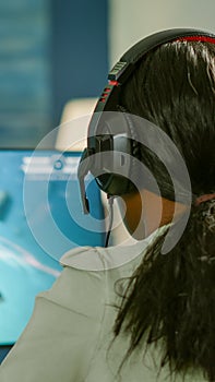 Closeup of competitive black woman player holding joystick playing space shooter