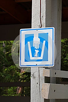 Closeup of a composting waster sign on a wooden post