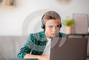 Closeup of concentrated schooler studying online from home