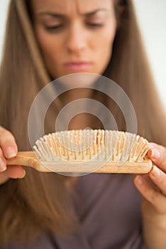 Closeup on concerned woman looking on hair comb