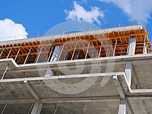 Closeup of concrete frame structure showing formwork for concrete slab. New multi-story apartment