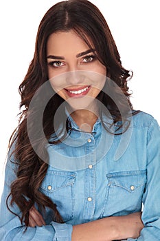 Closeup of a confident young casual woman with arms folded