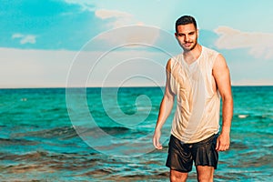 Healthy young man with a turquoise sea as a background