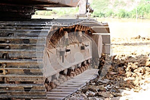 Closeup Continuous tracks or Tracked wheel of excavator or backhoe on the soil floor.