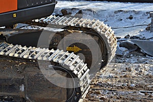 Closeup Continuous tracks or Tracked wheel of excavator or backhoe on the soil floor