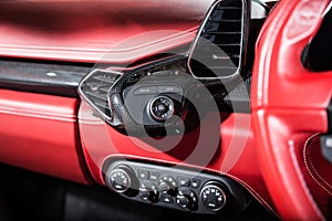 Closeup of the control buttons of a red luxury car under the lights