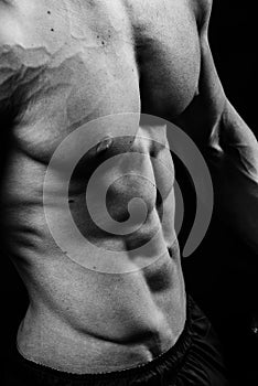 Closeup of cool perfect strong sensual bare torso with abs pectorals 6 pack muscles chest black and white studio