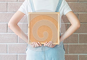 Closeup cork board in hand of woman in backside