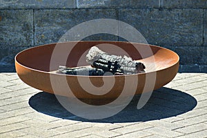 Closeup of a corten steel fire pit with burned wood