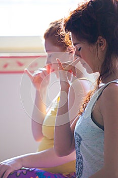 closeup of couple of women on yoga class exercises breathing technique healthy lifestyle concept