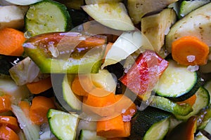 Closeup of courgettes, carrots, peppers, onion, aubergines and garlic cut ready to be cooked