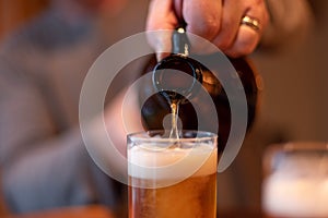 Closeup of craft beer being poured from a growler