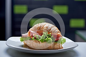 Closeup of croissant with greens, ham and vegetables in pub