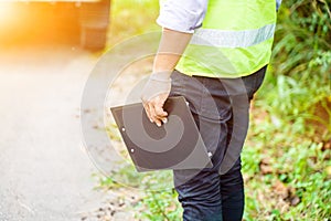 Closeup and crop insurance employee or service man holding a clipboard at locale