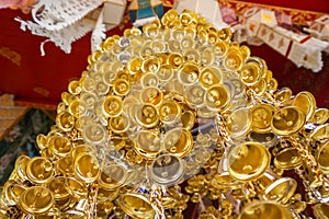 Look up view of of many small golden bells was hung in a group in Thai temple.